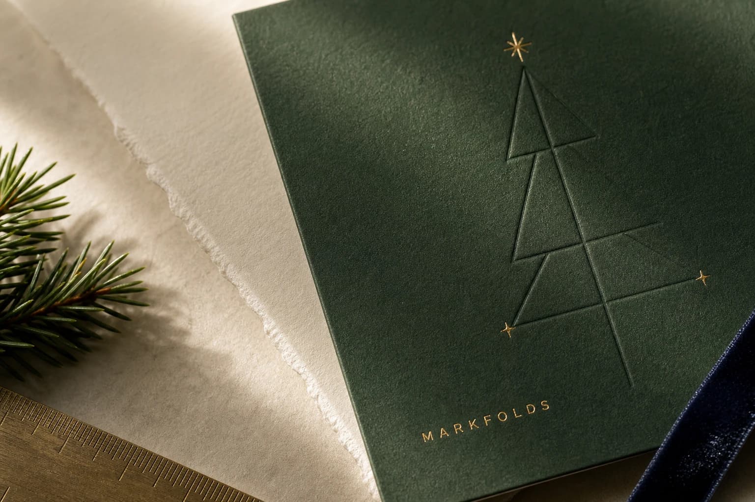 Close-up of embossed Christmas tree and gold foil details on a MARKFOLDS card